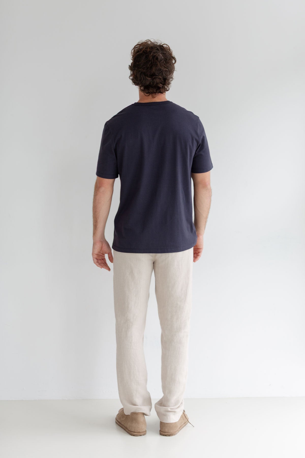 Navy roundneck tshirt men light pants full body view back