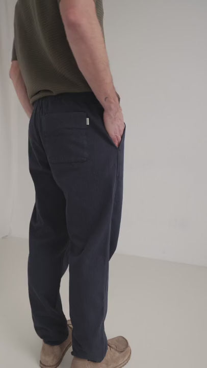 Navy straight leg pants men green shirt full body view