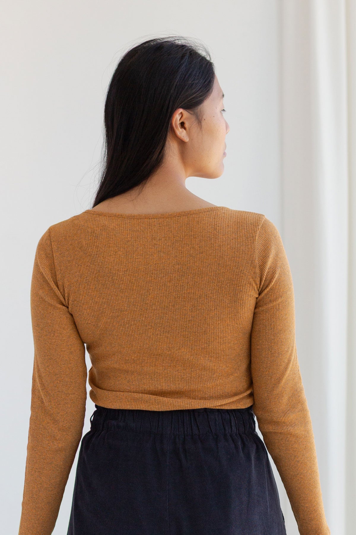 Back view of a nugget-yellow long-sleeve ribbed top.